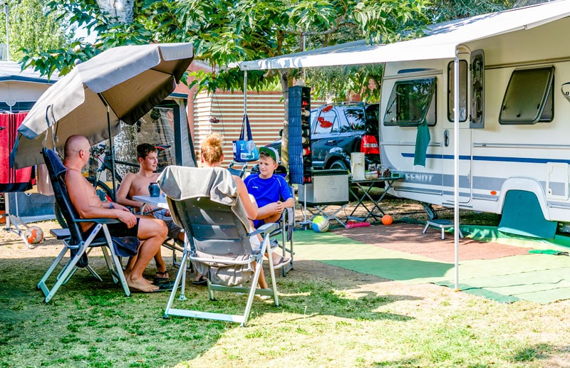 une famille heureuse au camping devant sa caravane Cala-Gogo